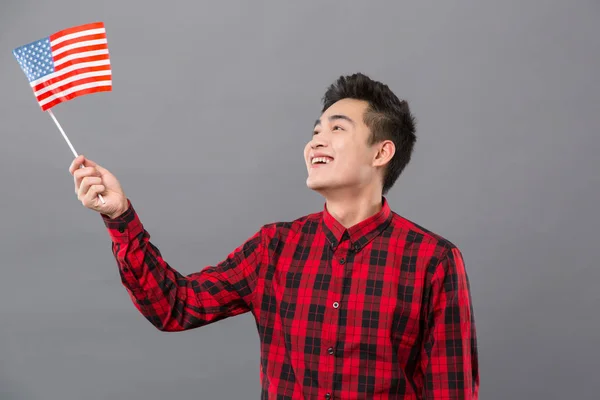 Glada positiva mannen tittar på USA flagga — Stockfoto