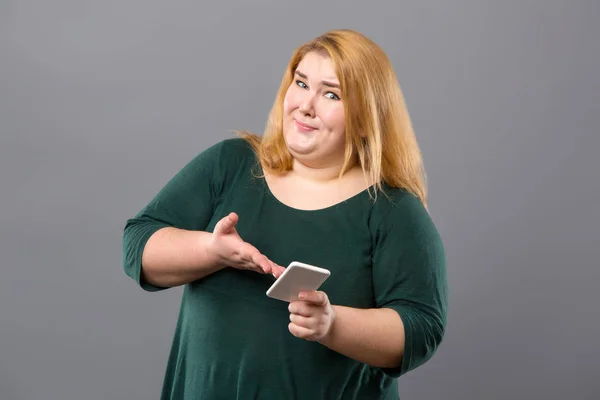 Mulher emocional agradável segurando seu smartphone — Fotografia de Stock