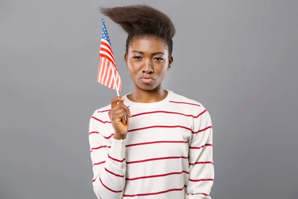 Confident young woman showing American flag
