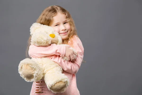 Zachwyceni miłą dziewczyną przytulaniu jej zabawki — Zdjęcie stockowe