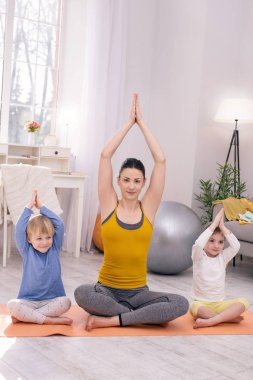 Mutlu anne ve çocukları yoga yaparken