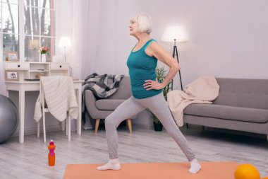 Hoş kadın kıdemli yapıyor sabah lunges