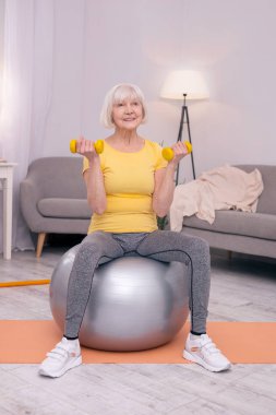Yaşlı kadın fitness Ball dumbbells ile egzersiz