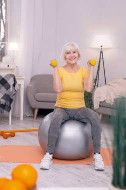 Üst düzey kadın fitness Ball dumbbells ile egzersiz yaparken poz