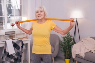 Sağlık değnek ile egzersiz yaparken gülümseyen kadın kıdemli neşeli