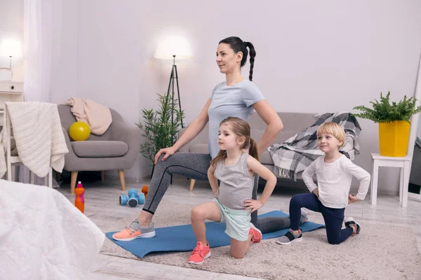 Cheerful mom training with her little kids — Stock Photo, Image