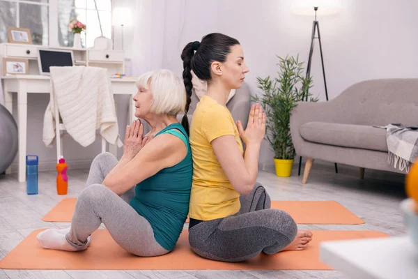 Mujeres concentradas haciendo yoga en casa —  Fotos de Stock