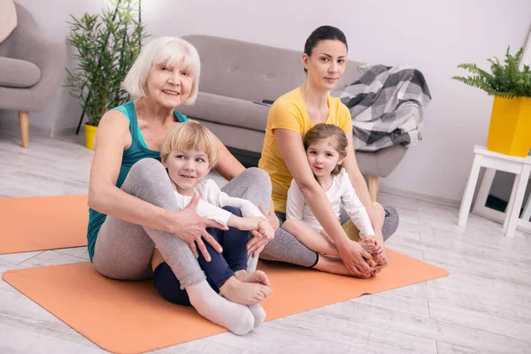 Smiling women and kids doing yoga — Stock Photo, Image