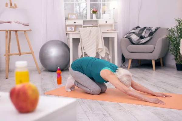 Atletik kadın kıdemli Yoga mat germe