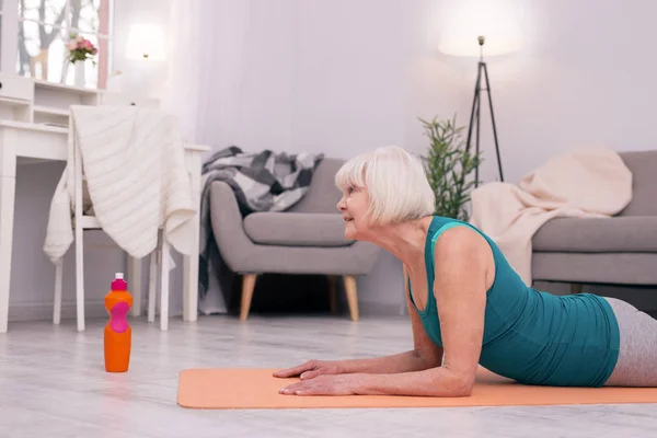 Agradable anciana ejercitando sus músculos del cuello — Foto de Stock