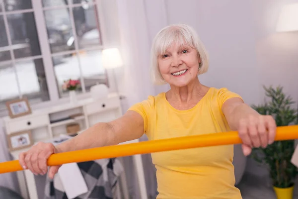 Joyeux senior femme tenant baguette santé et souriant — Photo