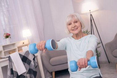 Mutlu yaşlı kadın ile mavi halter egzersiz