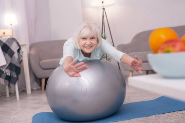 Çok güzel yaşlı bayan fitness topu üzerinde egzersiz