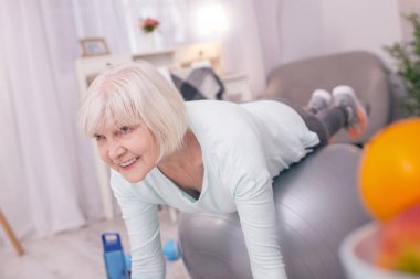 Denge ball üzerinde yalan ve tahta yapıyor neşeli yaşlı kadın