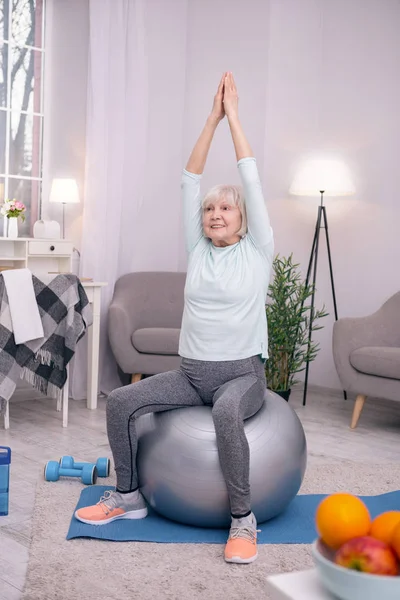 Gai senior femme étirant son dos sur équilibre ballon — Photo