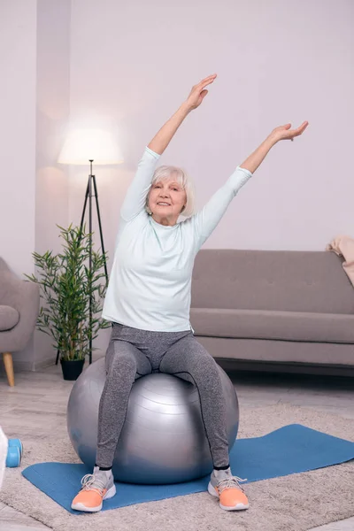 Kadın kıdemli yoga topu iken tarafında yaslanmış — Stok fotoğraf