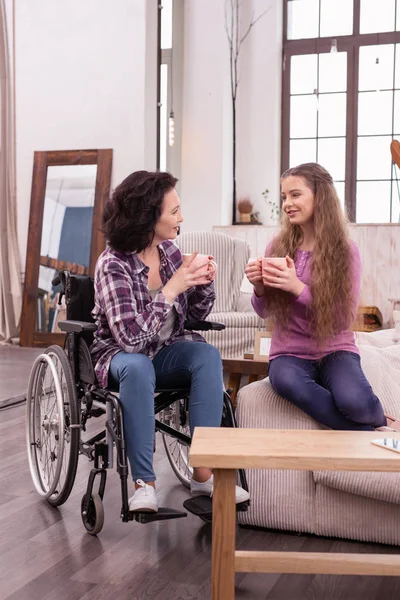 Mujer y niña discapacitada sincera disfrutando del té — Foto de Stock