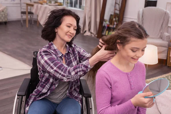 Encantadora mulher imóvel ajudando menina com penteado — Fotografia de Stock