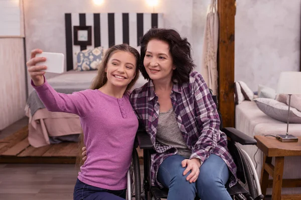 Happy crippled woman and girl taking photo — Stock Photo, Image