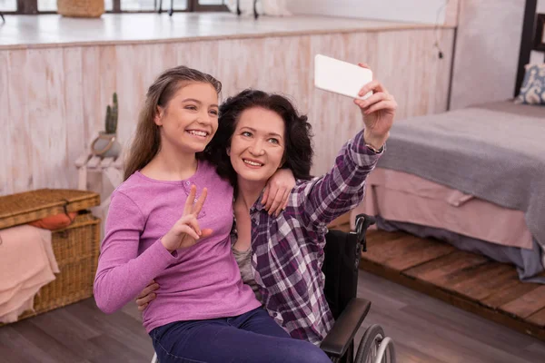 Joyful aleijado mulher e menina tomando selfie — Fotografia de Stock