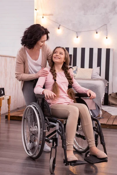 Mujer feliz cuidando de chica discapacitada — Foto de Stock