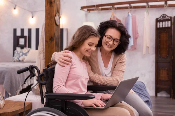 Inspirado chica y mujer discapacitada aprovechando el ordenador portátil — Foto de Stock