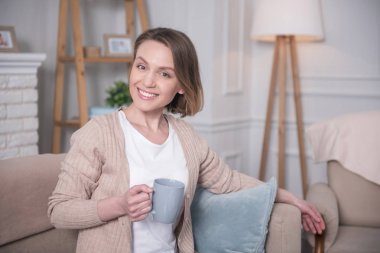 Kanepede oturan gülümseyen kadın.