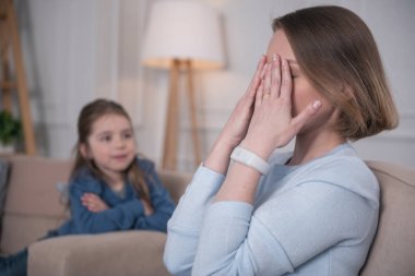 Yorgun anne elleriyle yüzünü kaplayan