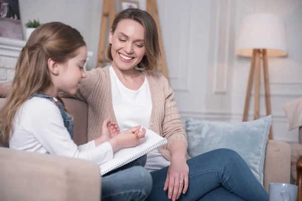 Alegre madre e hija sentadas en el sofá — Foto de Stock