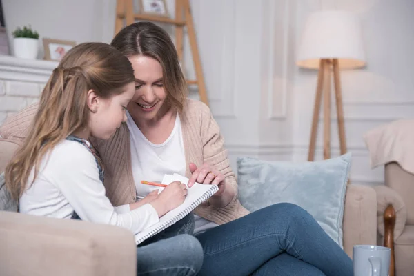 Deliziosi madre e figlia sedute sul divano — Foto Stock