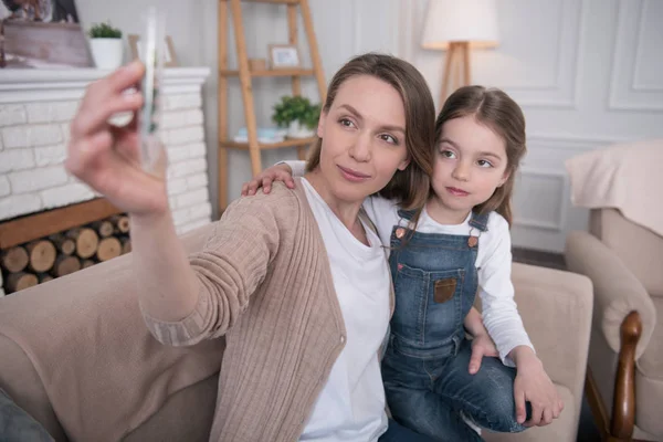 Madre e hija contentas mirando el tubo —  Fotos de Stock