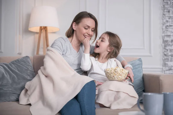 Exuberante madre e hija comiendo palomitas de maíz — Foto de Stock