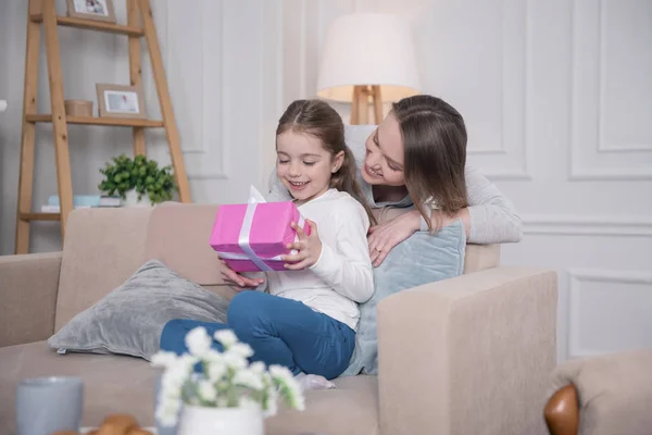 Chica encantada sosteniendo su regalo —  Fotos de Stock