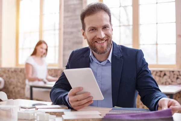 Gelukkig mannelijke ontwerper schatten van stof — Stockfoto