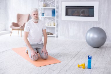 Beyaz saçlı komuta sizde Yoga mat üzerinde diz çökmüş