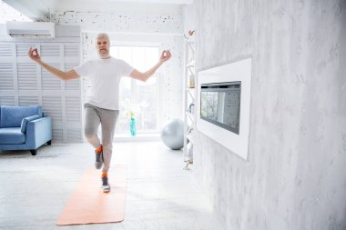 Atletik yaşlı adam evde meditasyon