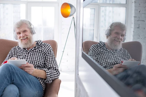 Encantador homem sênior posando enquanto assiste TV-show — Fotografia de Stock