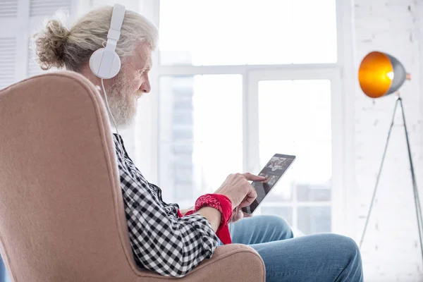Optymistyczne starszy człowiek sprawdzanie jego nową listę odtwarzania muzyki — Zdjęcie stockowe