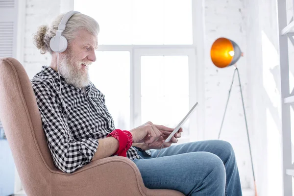 Affascinante uomo anziano che ascolta musica e chatta — Foto Stock