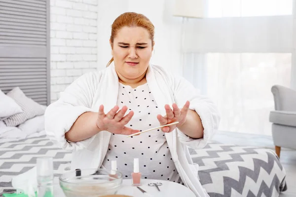 Ontevreden Mollige vrouw polijsten haar nagels — Stockfoto