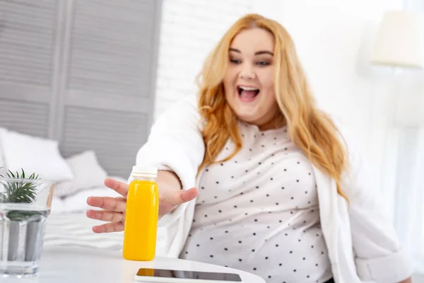 Mulher gorda inspirada tomando seu suco — Fotografia de Stock