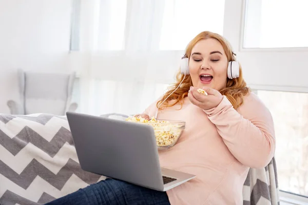 Sonriente mujer con sobrepeso viendo una película — Foto de Stock