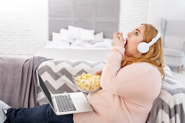 Inspirierte übergewichtige Frau beim Ansehen eines Films — Stockfoto