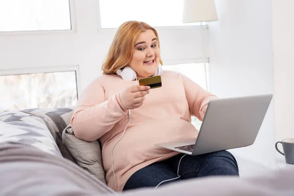 Mujer alegre con sobrepeso sosteniendo un crédito — Foto de Stock