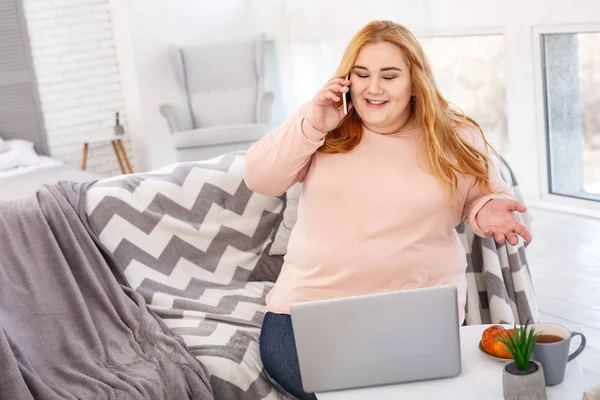 Femme dodue gaie parlant au téléphone — Photo