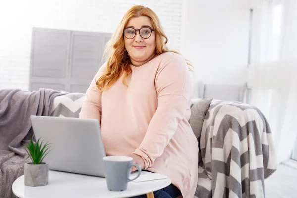 Innehåll stout kvinna som arbetar på sin laptop — Stockfoto