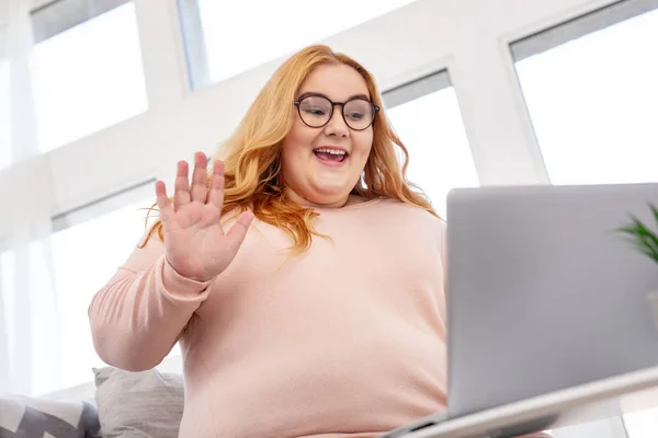 Mujer gorda feliz saludando y sentado con su portátil — Foto de Stock