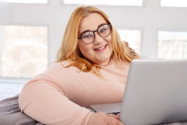 Radosny Gruba kobieta siedzi z jej laptop — Zdjęcie stockowe
