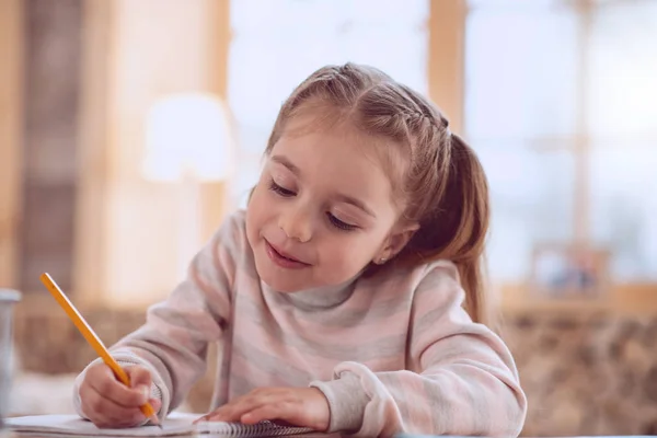 Nettes positives Mädchen hält einen Bleistift — Stockfoto