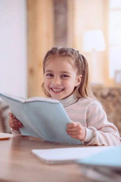 Menina positiva feliz lendo um livro — Fotografia de Stock